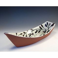 a ceramic boat with leaves and berries painted on it