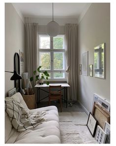 a living room filled with furniture next to a window covered in blankets and pictures on the wall