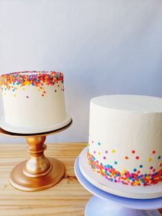 two white cakes with sprinkles on them