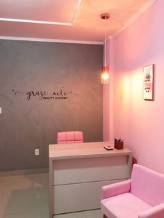 a pink chair sitting in front of a desk with a light on top of it