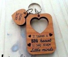 a wooden keychain with a heart shaped cutout on the front and back