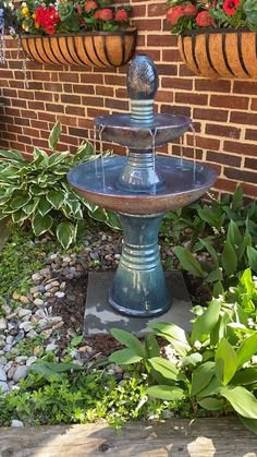 a water fountain sitting in the middle of a garden