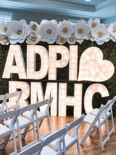 the letters and chairs are set up in front of a backdrop with flowers on it