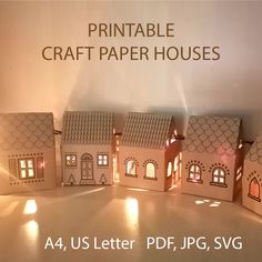 a group of paper houses sitting next to each other on top of a table in front of a sign that says printable craft paper houses