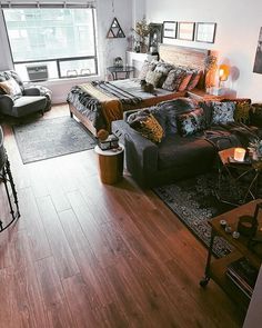 a living room filled with lots of furniture and decor on top of a hard wood floor