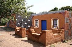 an adobe house with steps leading up to the front door and windows on each side