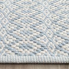 a blue and white rug on top of a wooden floor