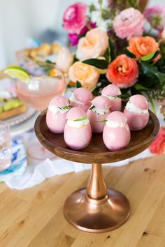 small chocolate eggs on a wooden plate with flowers in the background