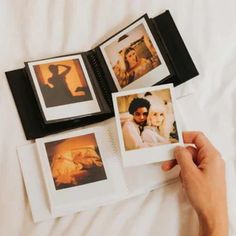 a person holding an open book with pictures on it and two photos in the pages