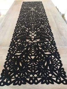 an intricately designed table runner made out of black paper