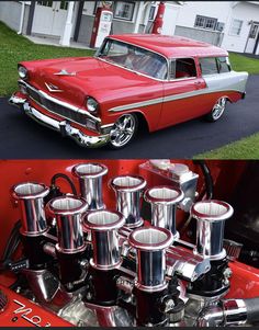 an old red car is parked in front of a white house and has chrome cups on the hood