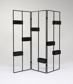 a black room divider with four shelves on each side