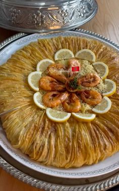 there is a large platter with shrimp and lemons on it