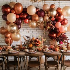 a dining room table is set with fall decorations and balloons