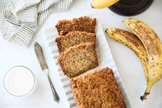 banana bread on a plate next to some bananas