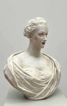 a white busturine with a red lipstick on it's face and shoulders