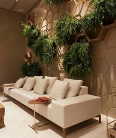 a living room filled with furniture and lots of greenery on the wall behind it