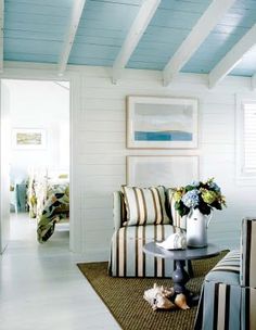 a living room with white walls and striped furniture