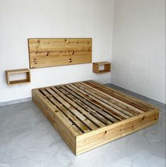 a bed made out of wooden pallets in a room with white walls and flooring