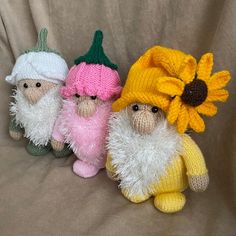 three small knitted gnomes sitting next to each other