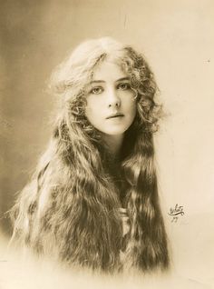 an old photo of a woman with long hair