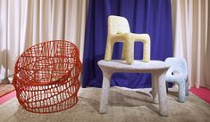 two chairs sitting next to each other on top of a carpeted floor in front of curtains