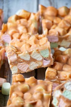 some kind of candy bar on a wooden table with marshmallows around it