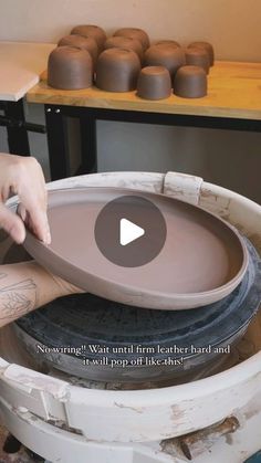 a person working on some pottery in a studio