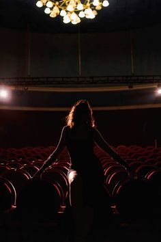 a woman standing in the middle of an auditorium