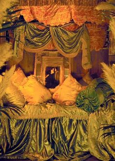 a man sitting on top of a bed in front of a mirror next to pillows