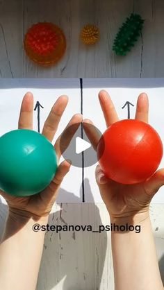 two hands are holding balls in front of a sign with numbers and arrows on it