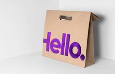 a brown paper bag with the word hello printed on it, sitting against a white wall