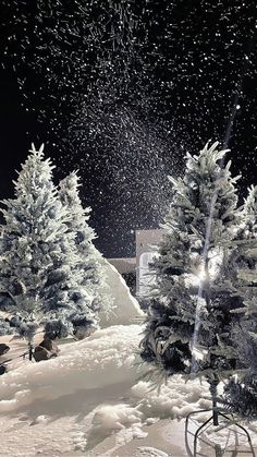 snow is falling from the sky over some trees