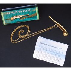 a gold necklace with a note attached to it and some other items on the table