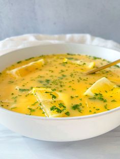 a white bowl filled with soup and garnished with parsley