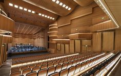 an empty auditorium with rows of seats and wooden walls