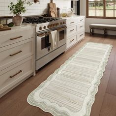 a kitchen with an oven, stove and rug in front of the counter top area