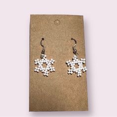 white beaded snowflake earrings on brown card