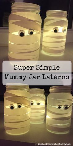 four jars with faces and eyes made out of paper strips, sitting on top of a table