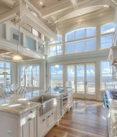 a large kitchen with an island in the middle and lots of windows on both sides