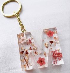 two glass blocks with flowers on them are hanging from a keychain that is attached to a chain