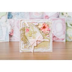 a card with flowers and lace on it sitting on top of a wooden table next to other cards