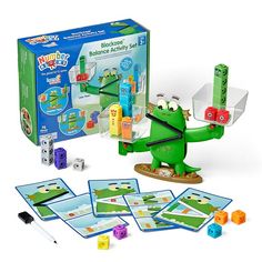 a green toy with blocks and dices in front of it, including an alligator