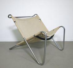 a folding chair sitting on top of a cement floor next to a white wall in an empty room