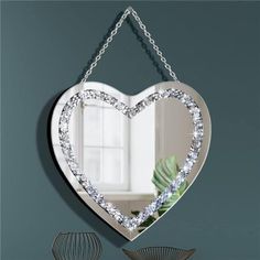 a heart shaped mirror hanging on the wall