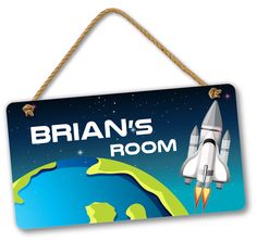 a wooden sign hanging from a rope with an image of a space shuttle on it