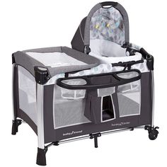 a baby crib with the door open and changing table attached to it's side