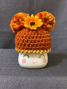 a crocheted hat with a sunflower on it's top is shown