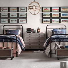 two beds in a room with pictures on the wall above them and below them is a dresser