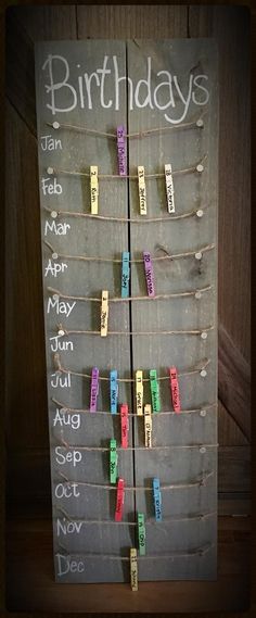 a birthday sign hanging on the side of a wooden door with clothes pins attached to it